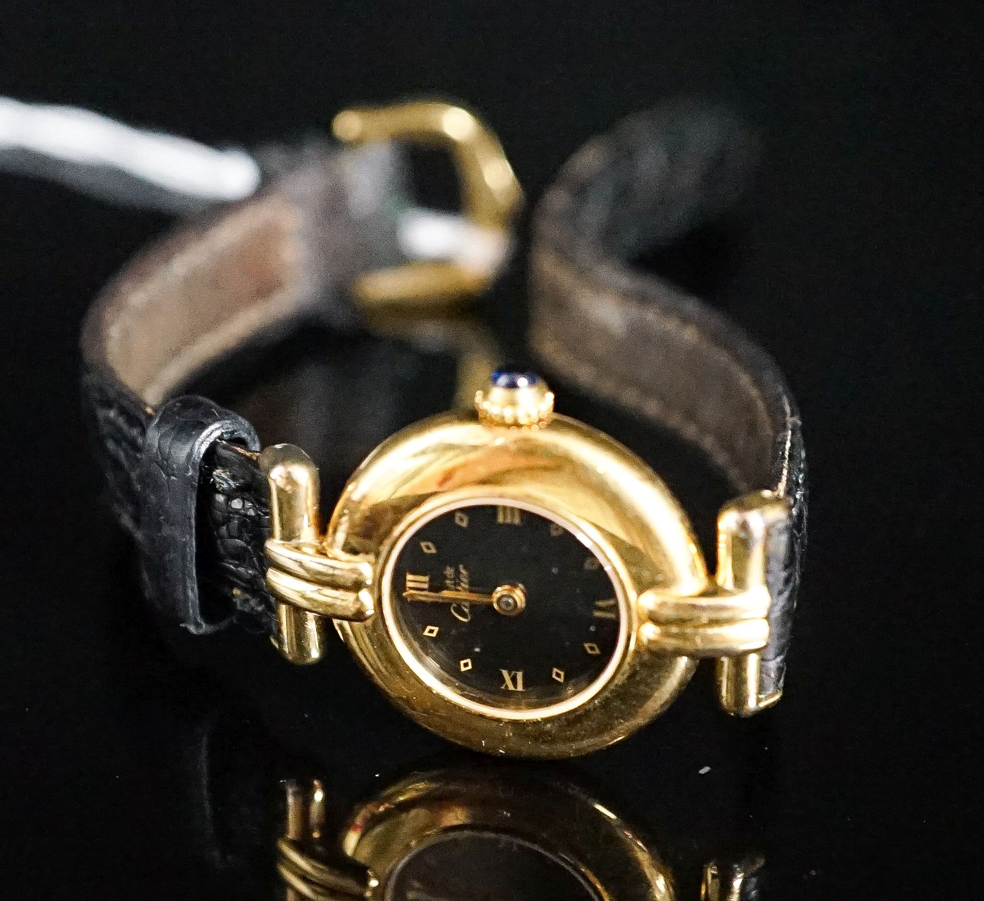 A lady's gilt white metal Must De Cartier quartz wrist watch, on a Cartier leather strap.